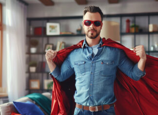 A REALTOR® dressed in a business suit and superhero cape, striking a powerful pose against a cityscape backdrop, representing the 'Prequalify for the Refi' program.